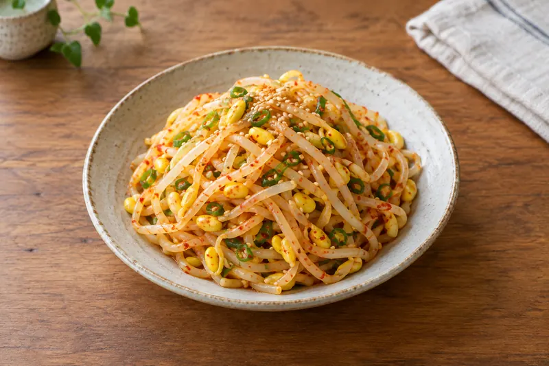 A small dish of yellow-headed soybean sprouts seasoned with sesame, spring onion and chilli